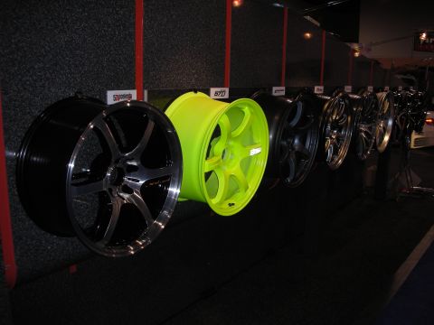 1998 Ford Crown Victoria - A variety of custom wheels are displayed on a wall, different styles and colors.