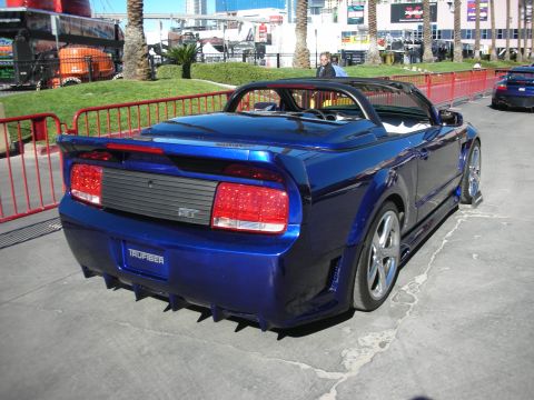 1998 Ford Crown Victoria - A custom blue convertible sports car is parked outdoors, with another car visible in the background.