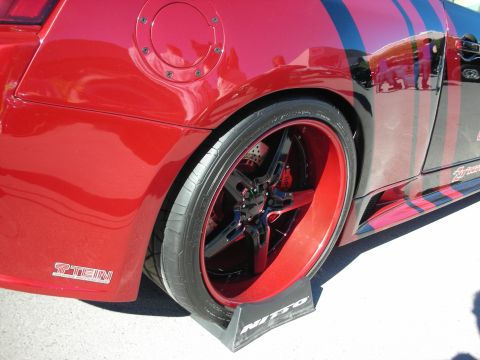 1998 Ford Crown Victoria - A custom red car with racing stripes and large aftermarket wheels is shown from the side.