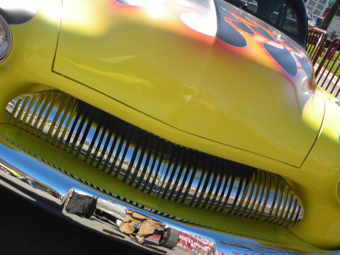 1998 Ford Crown Victoria - Close-up of a yellow hot rod flame graphics and a large, shiny chrome grille.