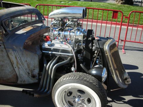 1998 Ford Crown Victoria - A heavily modified rat rod displays its powerful V8 engine and custom exhaust system.
