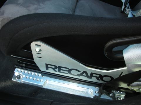 1998 Ford Crown Victoria - Close-up of a Recaro seat bracket, highlighting its metallic finish and branding.