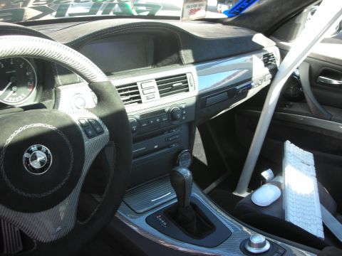 1998 Ford Crown Victoria - The interior of a car shows custom modifications including carbon fiber trim and a roll cage, with a keyboard and mouse on the passenger se…