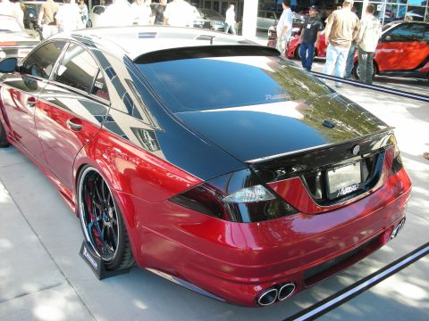1998 Ford Crown Victoria - Customized sedan with a two-tone paint job and dual exhaust pipes is displayed at an event.
