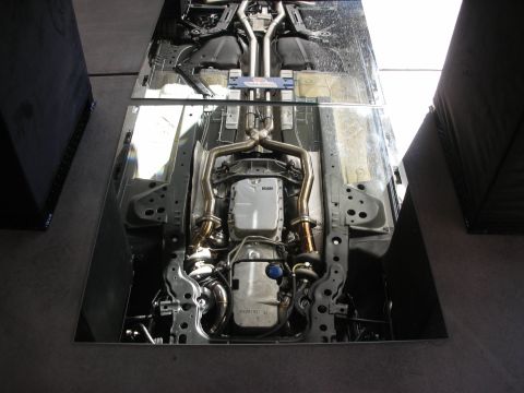 1998 Ford Crown Victoria - The undercarriage of a vehicle is viewed from below, revealing its exhaust system and transmission.