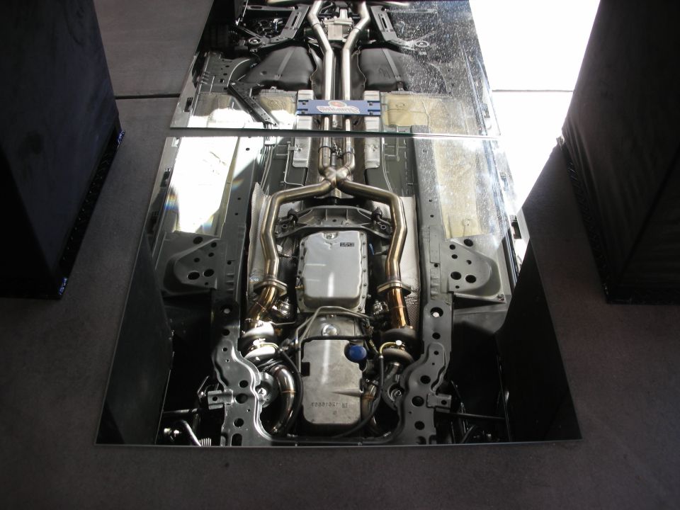 Underside of a car with dual exhaust and a silver transmission pan