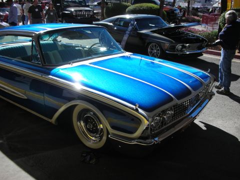 1998 Ford Crown Victoria - A dazzling blue custom coupe with distinctive chrome accents and whitewall tires is displayed at an outdoor event.