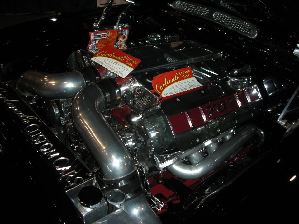 Black engine bay with chrome piping and red accents, two business cards on top