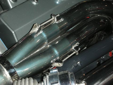 1998 Ford Crown Victoria - Polished exhaust pipes are visible with metal clamps and other engine components.