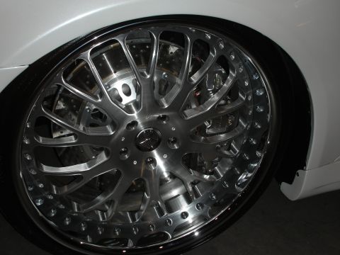 1998 Ford Crown Victoria - Close-up of a custom chrome wheel and tire assembly on a white vehicle.