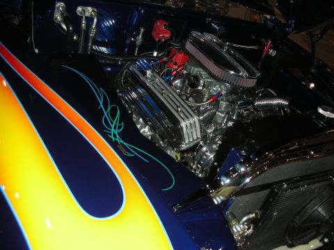 1998 Ford Crown Victoria - Customized engine bay a chrome V8 engine, air filter, and striking blue paint with flame graphics.