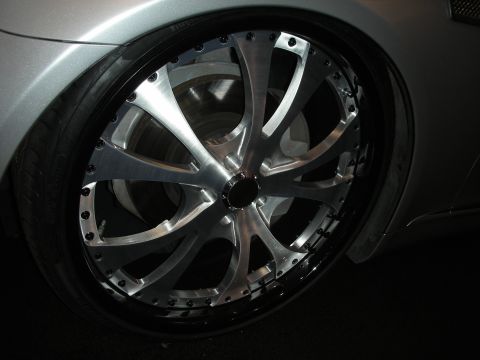 1998 Ford Crown Victoria - A close-up view of a custom chrome wheel and tire on a silver vehicle.