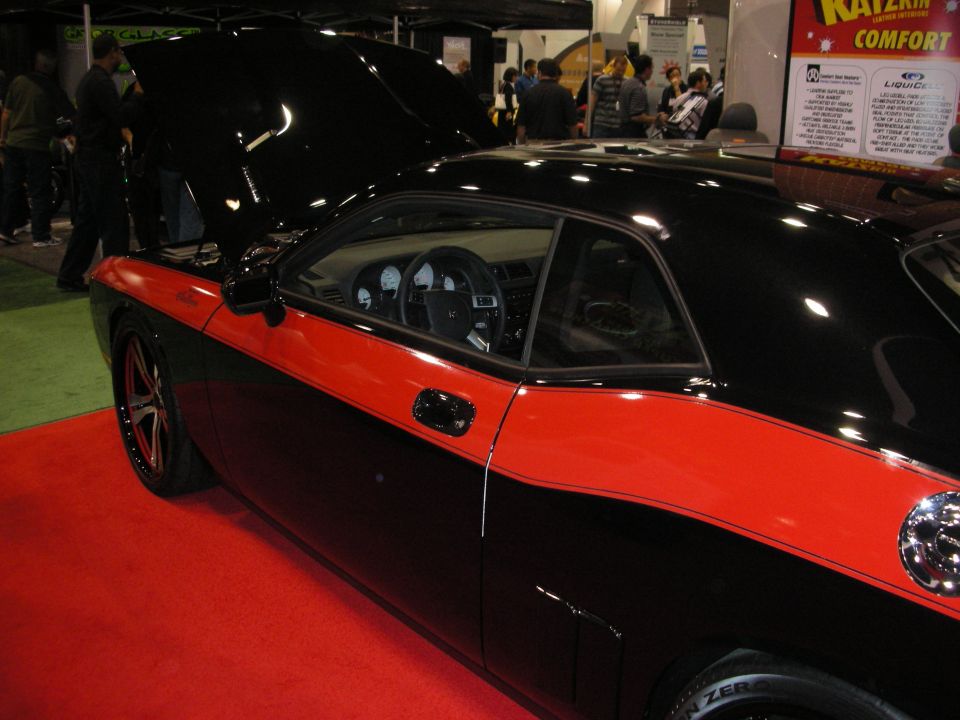 Black and red two-door coupe with hood open, red stripe along the side, and custom wheels