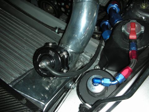 1998 Ford Crown Victoria - Close-up of a Tial blow-off valve and braided hoses within a vehicle's engine bay.