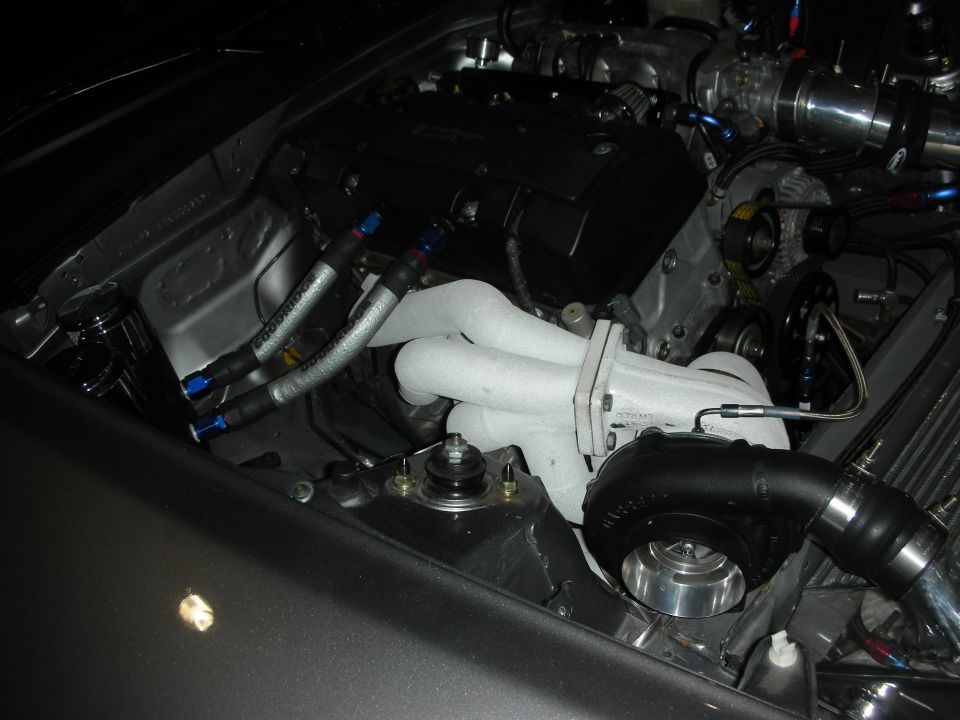 Engine bay showing a turbocharger, exhaust manifold, and fuel lines