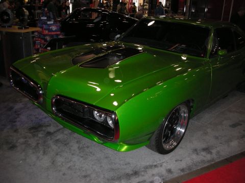 1998 Ford Crown Victoria - A bright green custom car is displayed indoors with another dark car in the background.