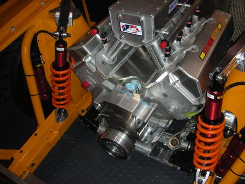 1998 Ford Crown Victoria - Close-up of a custom V8 engine with polished aluminum components and bright orange coilover shocks.