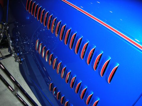 1998 Ford Crown Victoria - Blue car fender detail with red-lined vents and a red and white racing stripe.