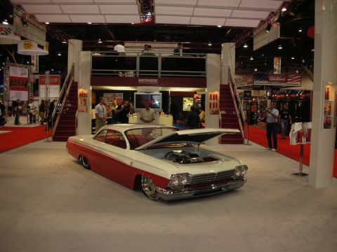 1998 Ford Crown Victoria - A customized classic car is displayed indoors with its hood open, revealing the engine.