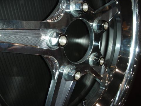 1998 Ford Crown Victoria - A close-up view of a custom chrome wheel, showing the lug nuts and the intricate design of the spokes.