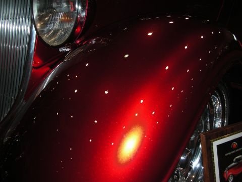1998 Ford Crown Victoria - Detail of a custom painted car fender, showing the metallic paint and reflections.
