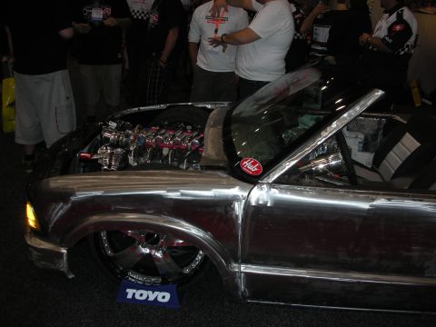 1998 Ford Crown Victoria - Customized pickup truck with polished metal body and exposed engine at an event. The "Hub" sticker is visible on the windshield.