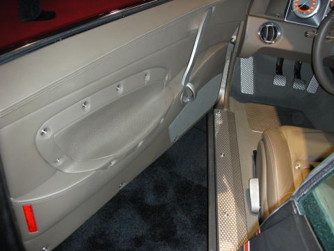 1998 Ford Crown Victoria - Interior view of a car, showing the door panel, seat, pedals, and a dashboard gauge.