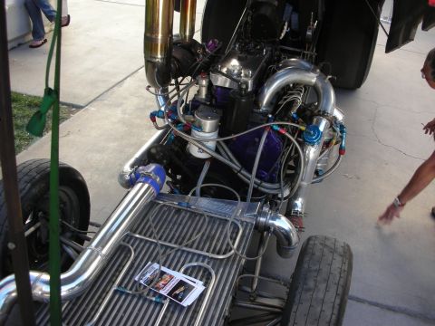 1998 Ford Crown Victoria - A highly modified engine bay of a drag car is shown, twin turbochargers and extensive plumbing.