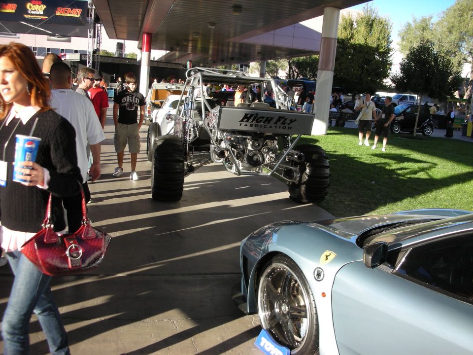 Custom buggy with "HIGH FLY FABRICATION" and a light blue sports car