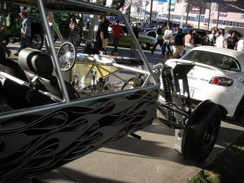 1998 Ford Crown Victoria - A custom dune buggy with flame graphics is parked on a street next to a white Mazda RX-8.