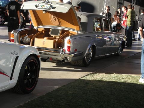 1998 Ford Crown Victoria - A custom Rolls-Royce Silver Shadow is displayed with its trunk open, revealing a unique interior setup.