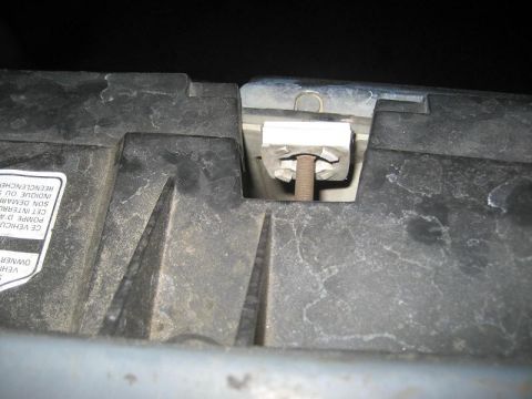 1987 Ford Bronco - A close-up view shows a plastic clip and bolt assembly on a vehicle's radiator support structure.