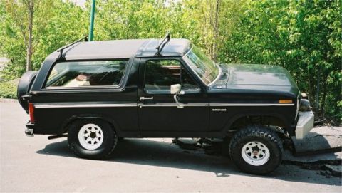 1985 Ford Bronco - This black 1985 Ford Bronco features a removable top and a spare tire mounted on the rear.