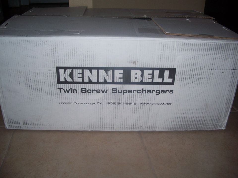 Cardboard box with Kenne Bell Twin Screw Superchargers logo and contact information