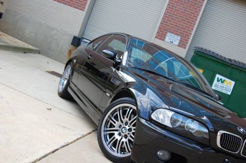2002 BMW M3 - Black 2002 BMW M3 coupe parked outdoors with a dumpster in the background.