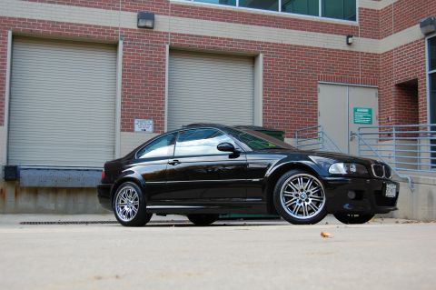 2002 BMW M3 - A black 2002 BMW M3 coupe is shown from a 3/4 front angle in front of a brick building.