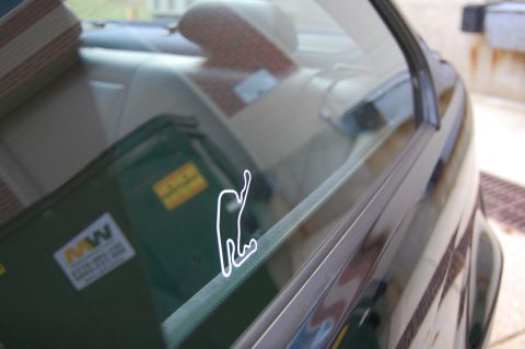 2002 BMW M3 - A race track sticker is visible on the interior window of a car, reflecting the outside environment.