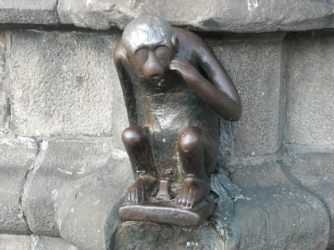 1979 Ford F-150 - A bronze monkey sculpture is affixed to a rough stone wall, appearing contemplative.