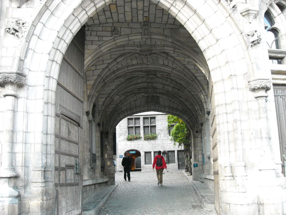 Stone archway with cobblestone path and two people walking away