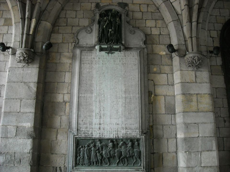 Carved stone war-memorial plaque with relief panels and a name list