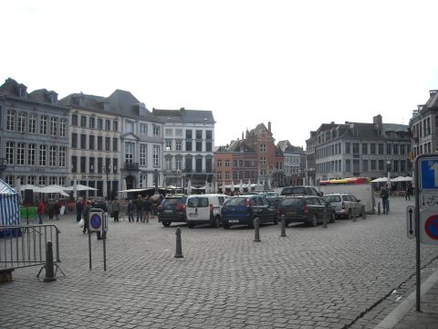 1979 Ford F-150 - Parked cars fill a cobblestone square in a European city, surrounded by traditional architecture.