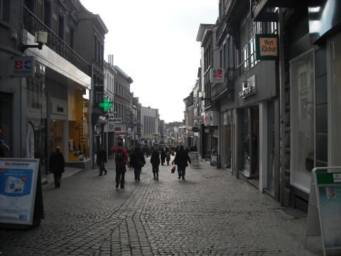 1979 Ford F-150 - A busy European street scene with shops and pedestrians on a cobblestone pavement.