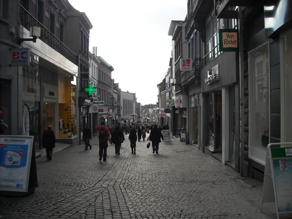 Cobblestone street lined with shops, people walking