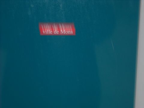 1979 Ford F-150 - A red rectangle with white text 'ville de Mons' is visible on a teal surface.