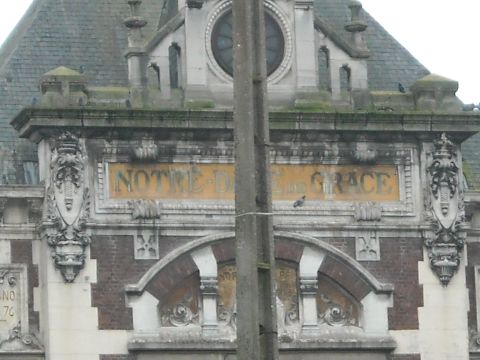 1979 Ford F-150 - Close-up of an old building's facade, decorative stonework and the inscription 'NOTRE-DAME DE GRACE'.
