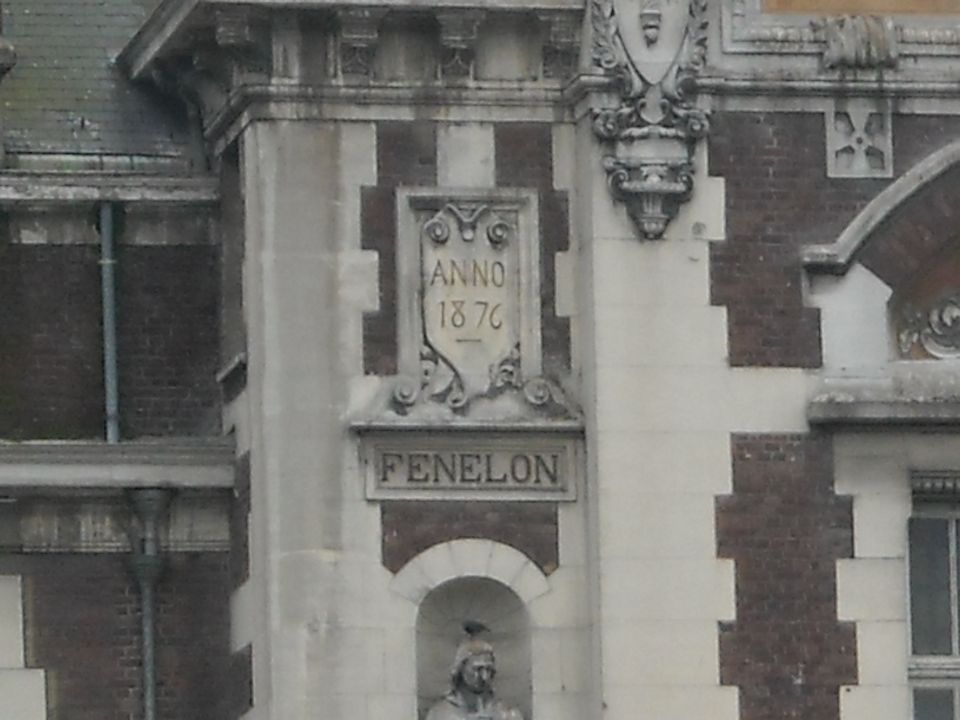 Building facade with "ANNO 1876" and "FENELON" inscriptions above a statue