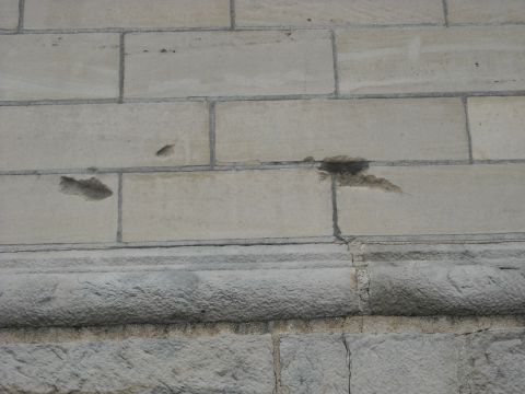 1979 Ford F-150 - Damaged stone blocks and trim on a building's exterior wall.