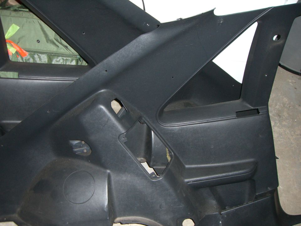 Black interior trim panel with cutouts and a circular speaker grille