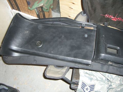 1988 Ford Bronco - Close-up of a black plastic dashboard trim panel, likely from an older vehicle, showing its texture and mounting points.