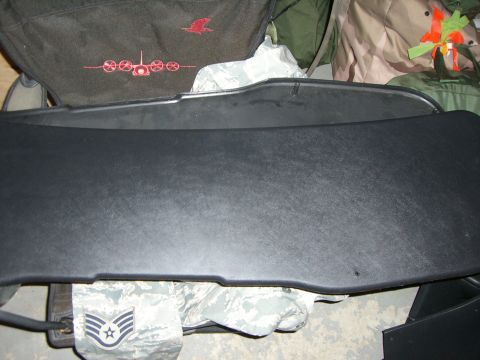 1988 Ford Bronco - A black dashboard trim piece is shown, with military fabric visible below.